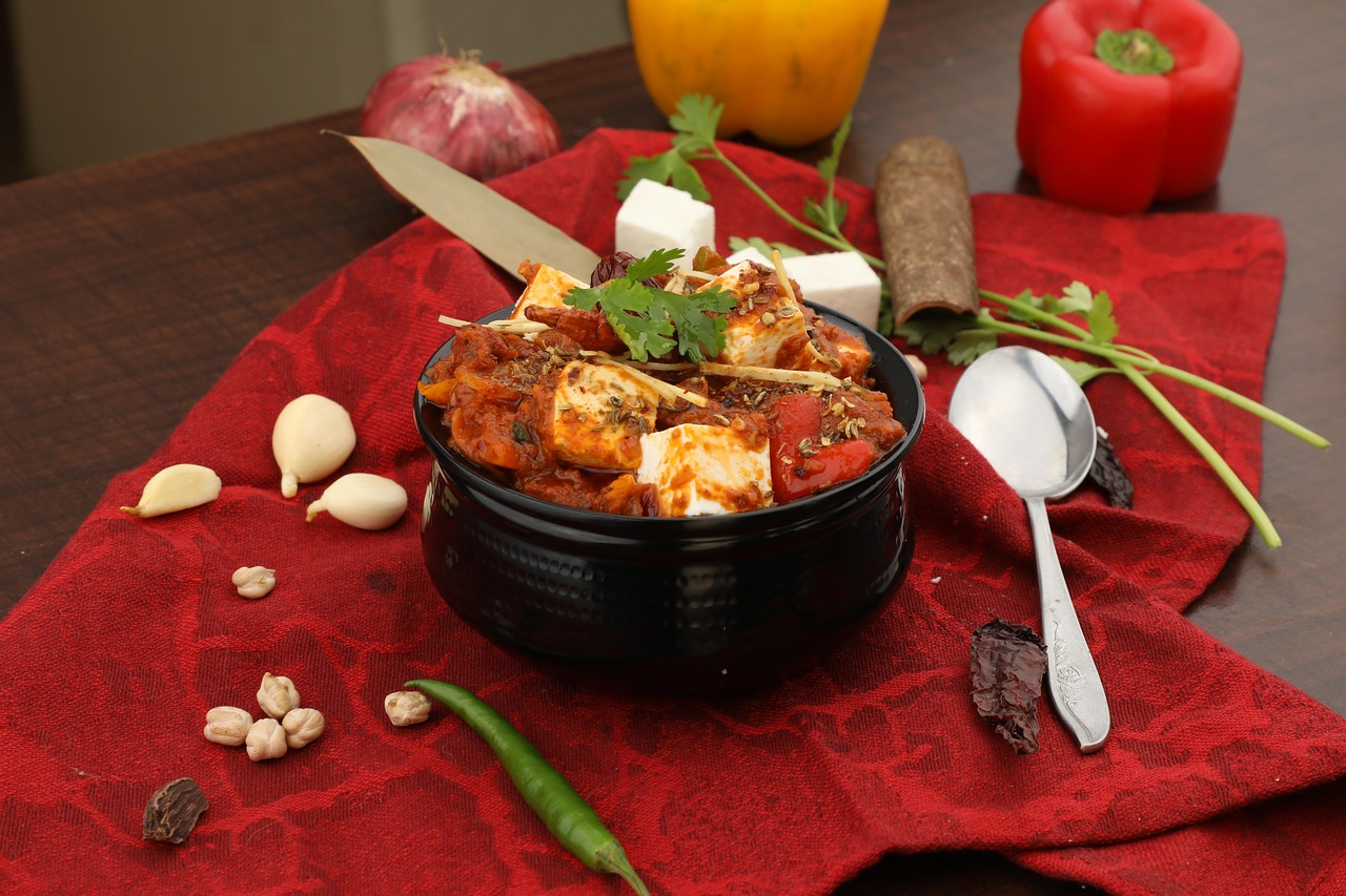 A pot of chilli paneer with peppers and coriander